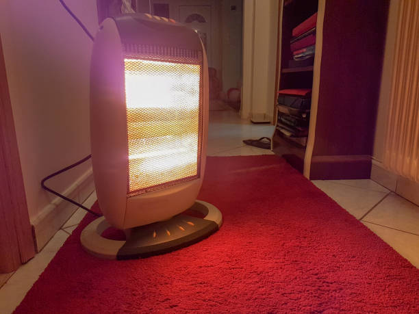 部屋のカーペットの冬に電気ヒーター - ハロゲン電球 ストックフォトと画像
