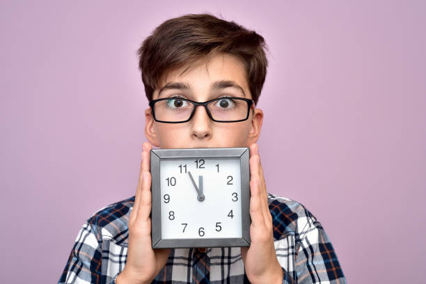 surprised young boy with a clock - clock face fotos imagens e fotografias de stock