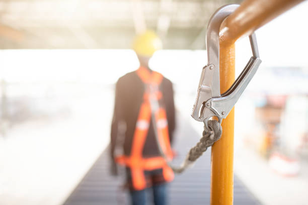 istock Industrial Worker with safety protective equipment loop hanging on the bar besides 1058369216