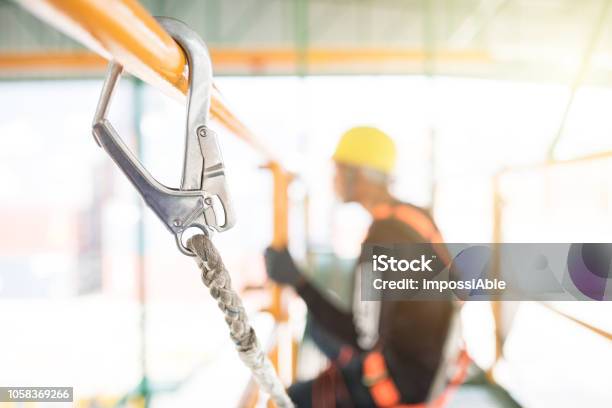 Industrial Worker With Safety Protective Equipment Loop Hanging On The Bar Besides Stock Photo - Download Image Now