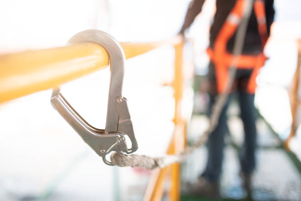 istock Industrial Worker with safety protective equipment loop hanging on the bar besides 1058369472