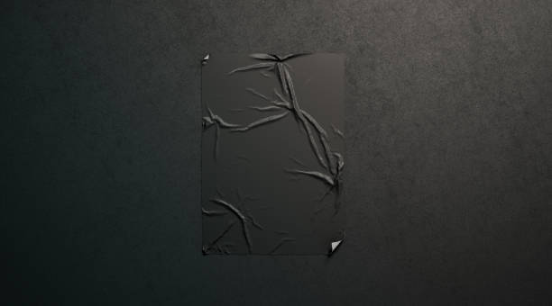 istock Blank black wheatpaste adhesive poster mockup on dark textured wall 1058372072