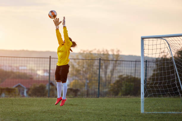 Female Soccer Player Female Soccer Player, Goalie On Training on Soccer Stadium Catching The Ball. sports training drill stock pictures, royalty-free photos & images