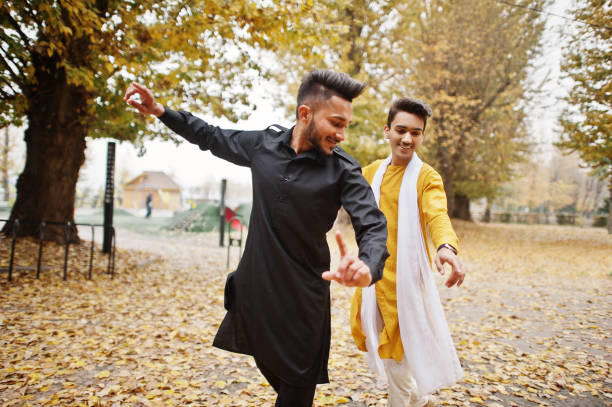 zwei indische stilvolle mans freunde in traditioneller kleidung - india indian culture traditional culture dancing stock-fotos und bilder