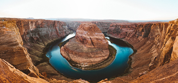 Classic wide-angle view of famous Horseshoe Bend, a horseshoe-shaped meander of the Colorado River located near the town of Page, in beautiful golden evening light at sunset in summer, Arizona, USA