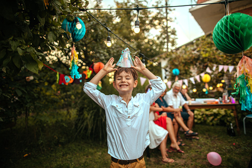 Father carrying smiling birthday boy on a party