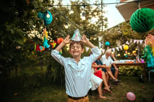 Father carrying smiling birthday boy on a party