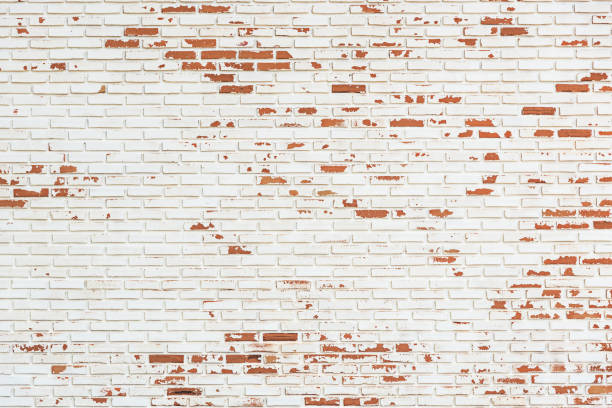 A close-up of two different brick walls against each other, with one painted white and the other painted red.