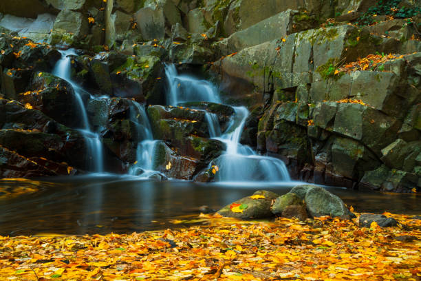 istock Waterfall in autumn forest with long exposure photo 1058383230