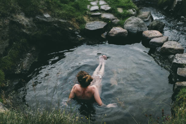 istock Woman resting in wild  hot spring in Iceland 1058384824