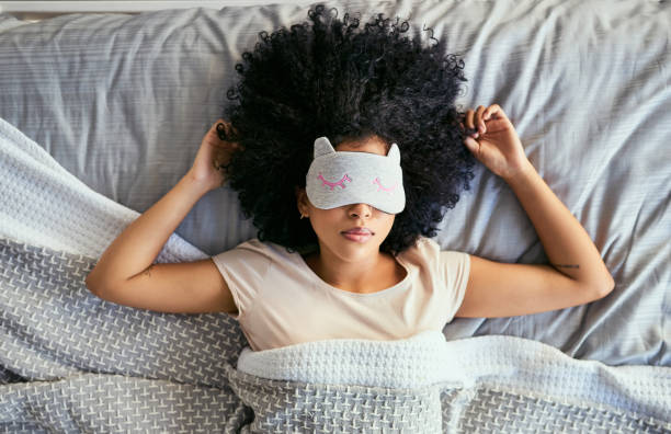 Do not disturb Shot of a young woman sleeping with a mask on in bed sleeping stock pictures, royalty-free photos & images