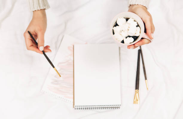 istock Empty blank,coffee,watercolor brush in woman's hands.Top view,flat lay 1058386216