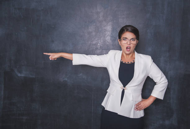istock Angry screaming teacher pointing out on blackboard 1058389592