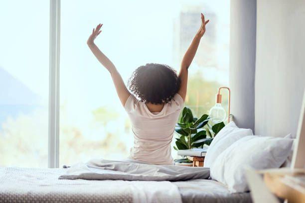 waking up on the right side of the bed - wake up stretching women black imagens e fotografias de stock