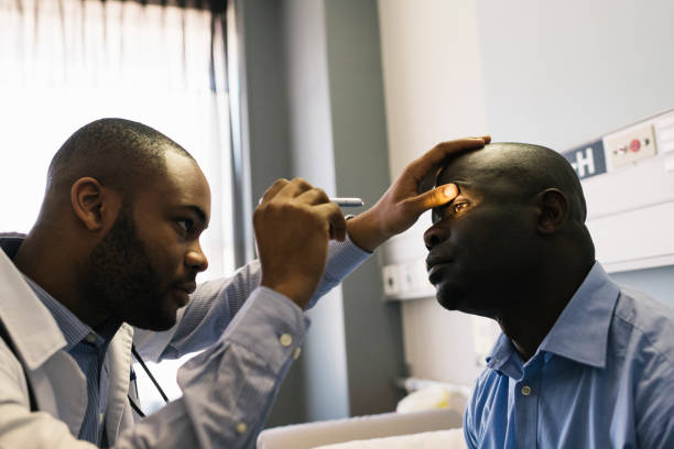 환자 눈 검사 ophthalmoscope와 젊은 아프리카 남자 의사 사용 - looking into each others eyes 뉴스 사진 이미지