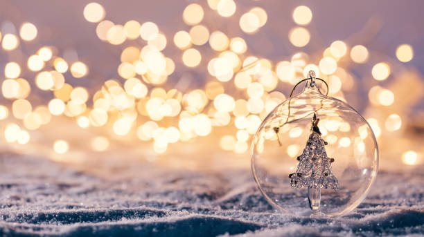 Christmas glass ball with tree in it on winter background. Christmas glass ball with tree in it on winter background. Snow and christmas lights. tranquil evening stock pictures, royalty-free photos & images