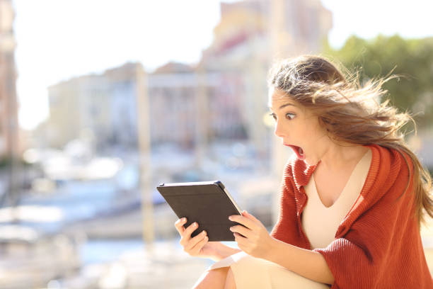 istock Shocked woman watching online content in a tablet 1058397272