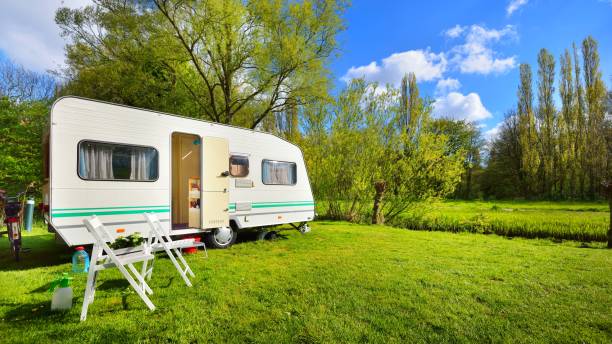 istock Caravan trailer on a green lawn, on a sunny spring day 1058402472
