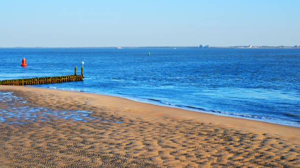 istock Red cargo ship and the sea under a cloudy blue sky 1058402560