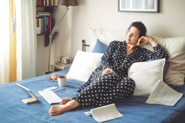 mujer adulta media en casa - ropa de dormir fotografías e imágenes de stock