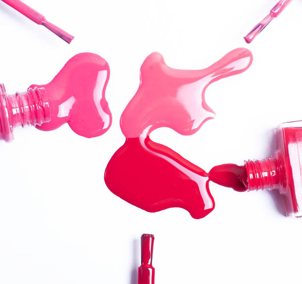 istock nail Polish pink spilled and brush on white background. 1058406850