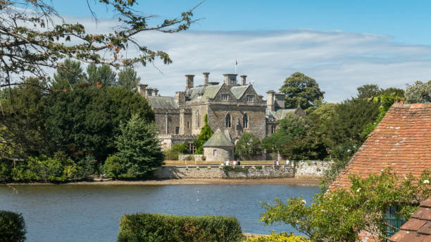 la maison de palace dans le village de beaulieu dans le parc national new forest (angleterre, royaume-uni) situé sur un lac, une journée ensoleillée - hampshire photos et images de collection