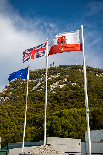 Gibraltar, United Kingdom, 1st October 2018:- The flags of Gibraltar, United Kingdom and the EU flying in Gibraltar. Gibraltar is a British Overseas Territory located on the southern tip of Spain.