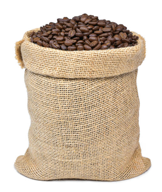 Roasted coffee beans in a burlap sack Roasted coffee beans in a burlap sack. Sackcloth bag with coffee beans, isolated on white background. Coffee export. roasted coffee bean photos stock pictures, royalty-free photos & images