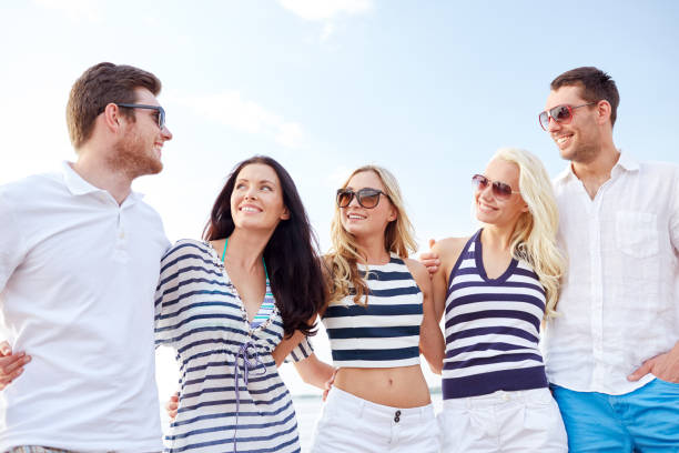 istock smiling friends in sunglasses talking on beach 1058427252