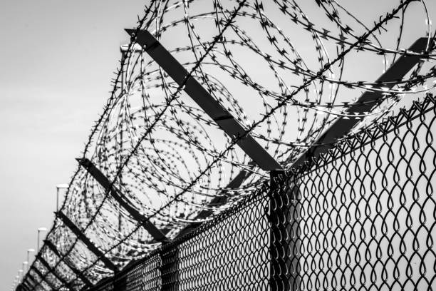istock Razor Wire Fence Against Sky 1058430506