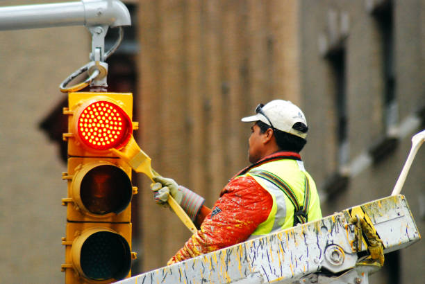 New York, NY, USA May 10, 2009 A City Worker Gives a New York City Street Light a Fresh Coat of Yellow Paint
