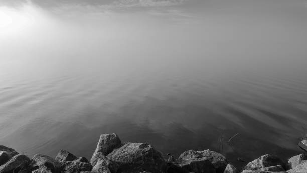 istock Thick fog on lake. Monochrome misty water. 1058434892