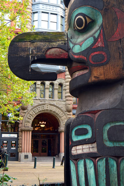 Totem Pole at Pioneer Square, Seattle Seattle, WA, USA October 24, 2014 A large wooden Tingit totem pole, crafted by native Alaskans in 1937, dominates Pioneer Square in Seattle, Washington. pacific northwest totem poles stock pictures, royalty-free photos & images