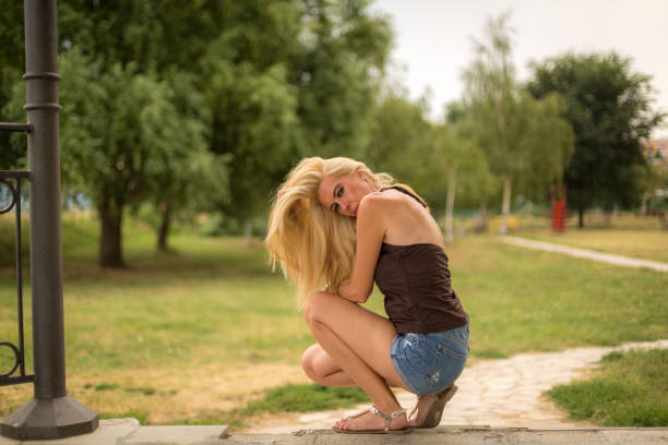 Beautiful young woman relaxing on jetty above lake