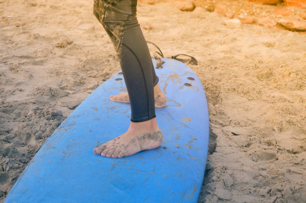istock Kid’s feet on surf board 1058435440