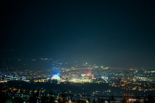 Una visión amplia de luces de la ciudad en las colinas por la noche, con centro de convenciones de Kigali se iluminó con los colores de la bandera de Ruanda photo