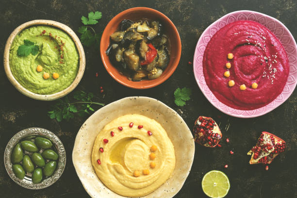 istock A variety of colored hummus, classic, beetroot and avocado. Top view, dark rustic background. Toned photo. 1058445416