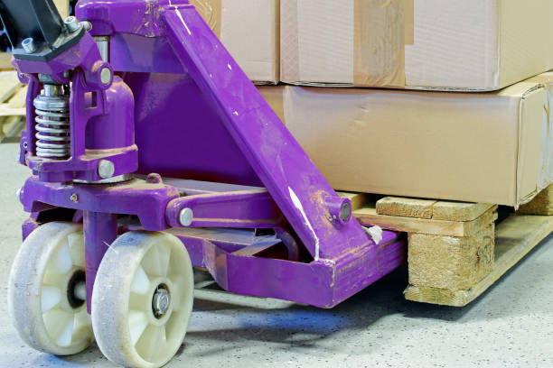 Purple hand pallet truck Purple hand pallet truck with cardboard boxes close up. pallet jack handle stock pictures, royalty-free photos & images