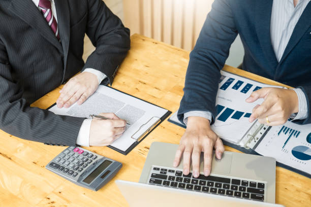 istock Midsection Of Business People Working At Desk 1058457790