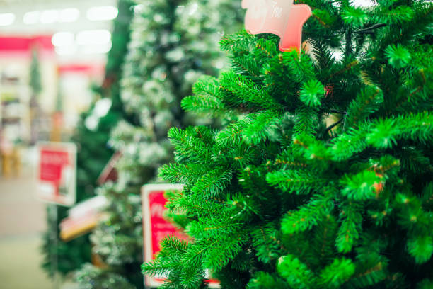 市場、ショップでの販売のための人工グリーン クリスマス ツリーを閉じます。クリスマス ・ イヴ、新年のパーティーのための prepearing。選択と集中、コピー スペース。 - pine tree christmas tree green ストックフォトと画像