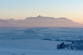 Scenic view of snow-covered fields and sunrise in the High Tatras mountains.