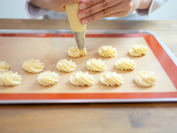 istock Hands piping butter cookies on baking tray. 1058463812