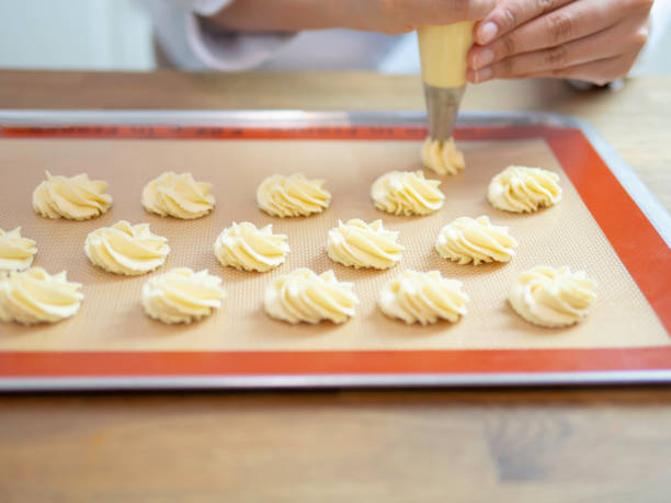 istock Hands piping butter cookies on baking tray. 1058463830