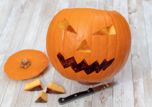 istock Cutting a pumpkin with a knife for Halloween 1058465742