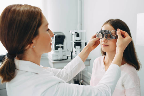 istock Eye doctor examining girls vision using a trial frame 1058465766