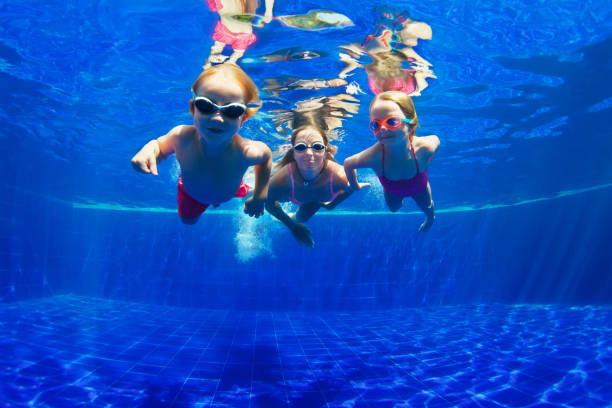 feliz familia inmersión bajo el agua en piscina - watersports centre fotografías e imágenes de stock