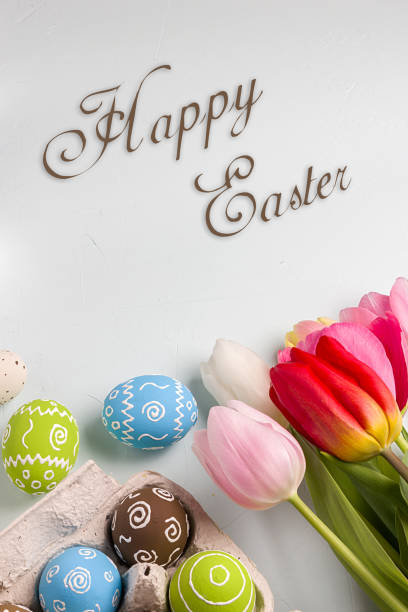 istock Painted easter eggs and branches of spring sakura closeup on a light blue background with space for congratulation 1058479154