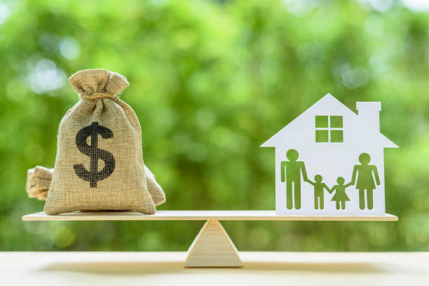 family financial management, mortgage and payday loan or cash advance concept : dollar bags, 4 members family under a house or shelter on a balance scale, depicts short term borrowing for a residence. - burlap sack fotos imagens e fotografias de stock