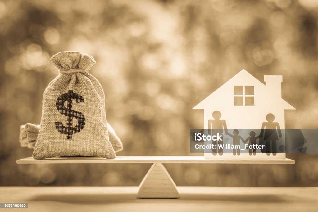 Legacy / inheritance or death tax concept : US dollar bag, a house and family members e.g father, mother, son, daughter on a balance scale, depicts a tax paid by person who inherits money or property. Will - Legal Document Stock Photo