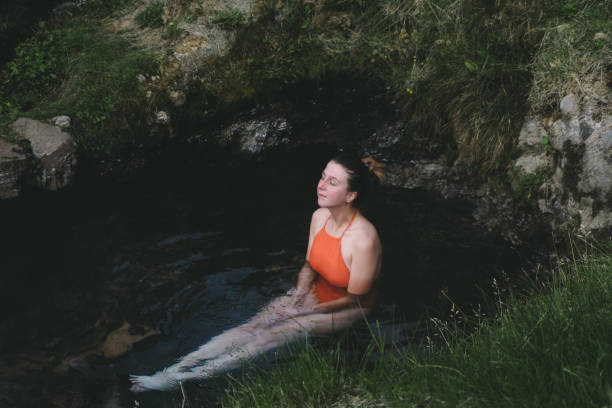 istock Woman resting in geothermal hot spring in Iceland 1058486538